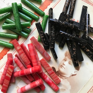May include: Assortment of colourful glass rods, including green, black with gold flecks, and red with white stripes. The rods are approximately 2.5 cm long and are perfect for crafting projects.