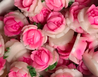May include: A bowl filled with pink and white plastic rose flower embellishments. The roses are small and have a realistic appearance.