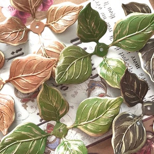 May include: Assortment of decorative metal leaves in various shades of green, brown, and gold. The leaves have a textured, embossed design and are perfect for crafting projects.
