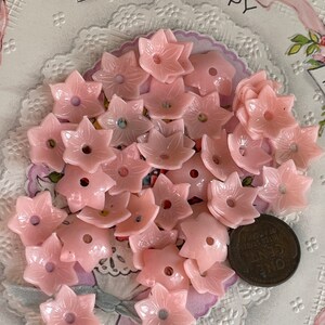 Peut inclure: Un tas de boutons en plastique rose en forme de fleur avec un trou au centre. Les boutons mesurent environ 2,5 cm de diam&egrave;tre.
