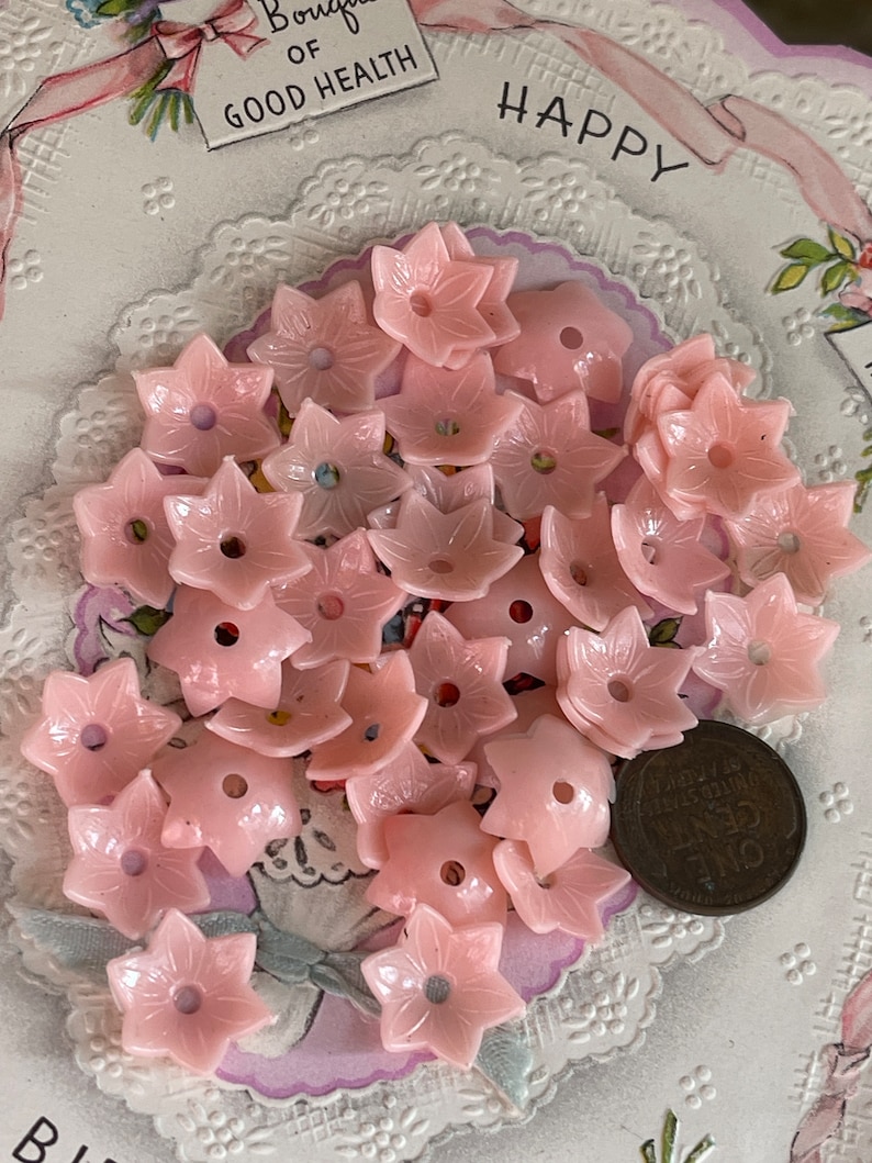 Peut inclure: Un tas de boutons en plastique rose en forme de fleur avec un trou au centre. Les boutons mesurent environ 2,5 cm de diam&egrave;tre.