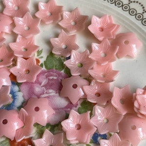 Peut inclure: Un ensemble de boutons en plastique rose en forme de fleur. Les boutons ont une forme d'&eacute;toile &agrave; cinq branches avec un trou au centre.
