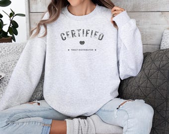 May include: A gray sweatshirt with the text "CERTIFIED TREAT DISTRIBUTOR" and a small heart graphic.