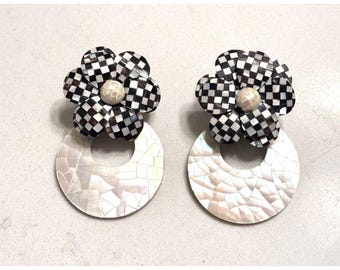 Brincos pendentes com estampa floral xadrez em madrepérola, preto e branco, estilo moderno.