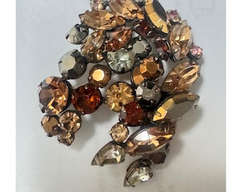 Broche dimensional estilo Regência com uma mistura de pedras em tons de conhaque intenso, topázio fumê e hematita.
