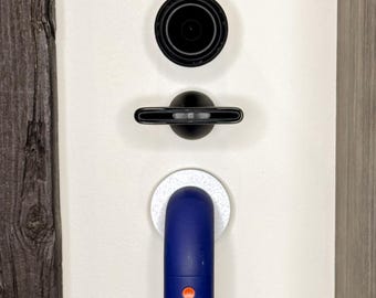 May include: A blue and orange handheld vacuum cleaner with a white circular base is mounted on a white wall. The vacuum cleaner has two orange buttons and the text "FILTER" is visible on the side.