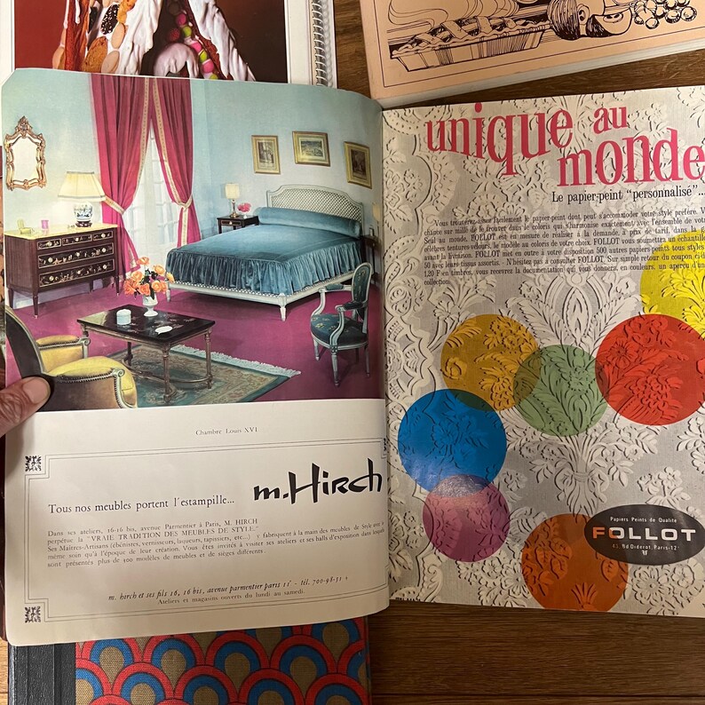 May include: A vintage advertisement for m. Hirch furniture featuring a bedroom with a blue bed, a dark wood dresser, and a yellow armchair. The text reads "Tous nos meubles portent l'estampille... m. Hirch".