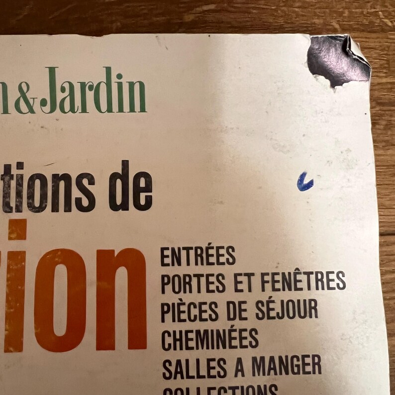 May include: A vintage book cover with the title "Decorations de l'Int&eacute;rieur et du Jardin" in French. The cover is white with orange and black text. The text below the title lists different rooms of a house, including "Entr&eacute;es", "Portes et Fen&ecirc;tres", "Pi&egrave;ces de S&eacute;jour", "Chemin&eacute;es", and "Salles &agrave; Manger".