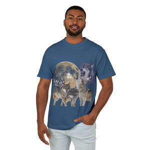 May include: A navy blue t-shirt with a graphic of wolves howling at the moon. The moon is yellow with a starry sky behind it.