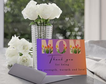 May include: A purple and orange gradient card with the word "MOM" in large black letters. The letters are filled with colorful tulips. The card reads "Thank you for being my strength, warmth and love!"