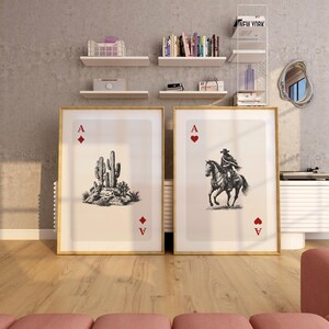 K&ouml;nnte beinhalten: Zwei gerahmte Kunstdrucke mit Spielkartenmotiven. Einer zeigt einen Kaktus, der andere einen Cowboy auf einem Pferd. Beide haben goldene Rahmen und die Symbole Pik und Herz.