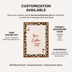 May include: Customizable playing card art print with a leopard print border and wooden frame. The card features the Ace of Hearts and space for custom text. Background color options include leopard, zebra, red, and cream.