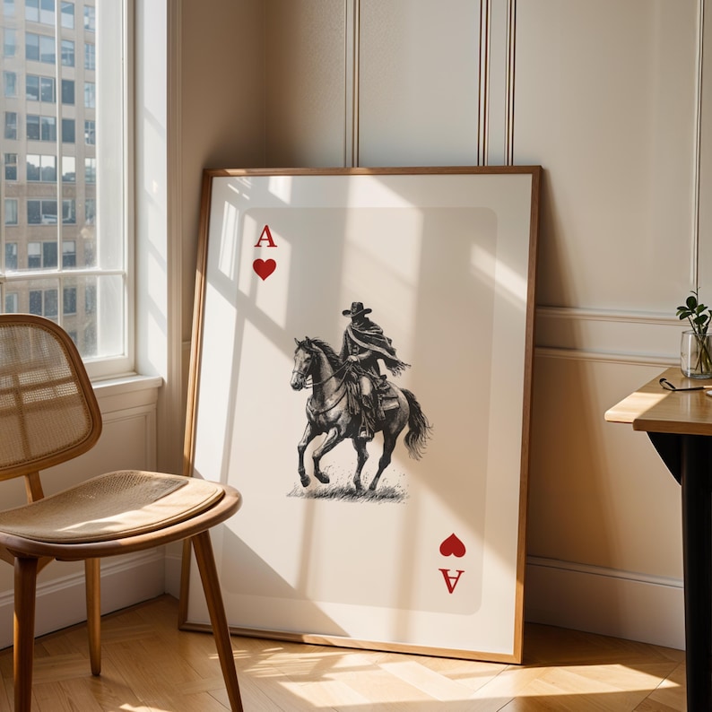 K&ouml;nnte beinhalten: Gerahmter Kunstdruck der Herz-Ass-Spielkarte. Die Karte zeigt eine Schwarz-Wei&szlig;-Illustration eines Cowboys auf einem Pferd. Die Karte hat ein rotes Herzsymbol und den Buchstaben "A" in den oberen und unteren Ecken.
