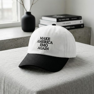 May include: A set of three ceramic mugs with a speckled, cream-colored glaze. Each mug features a different hand-painted design: a blue and green leaf, a yellow flower, and a red berry. The mugs have a simple, rounded shape.