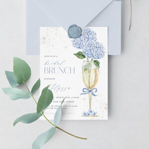 This beautiful design features delicate blue hydrangea flowers, in a gold champagne glass, perfect for your bridal shower or brunch celebration.