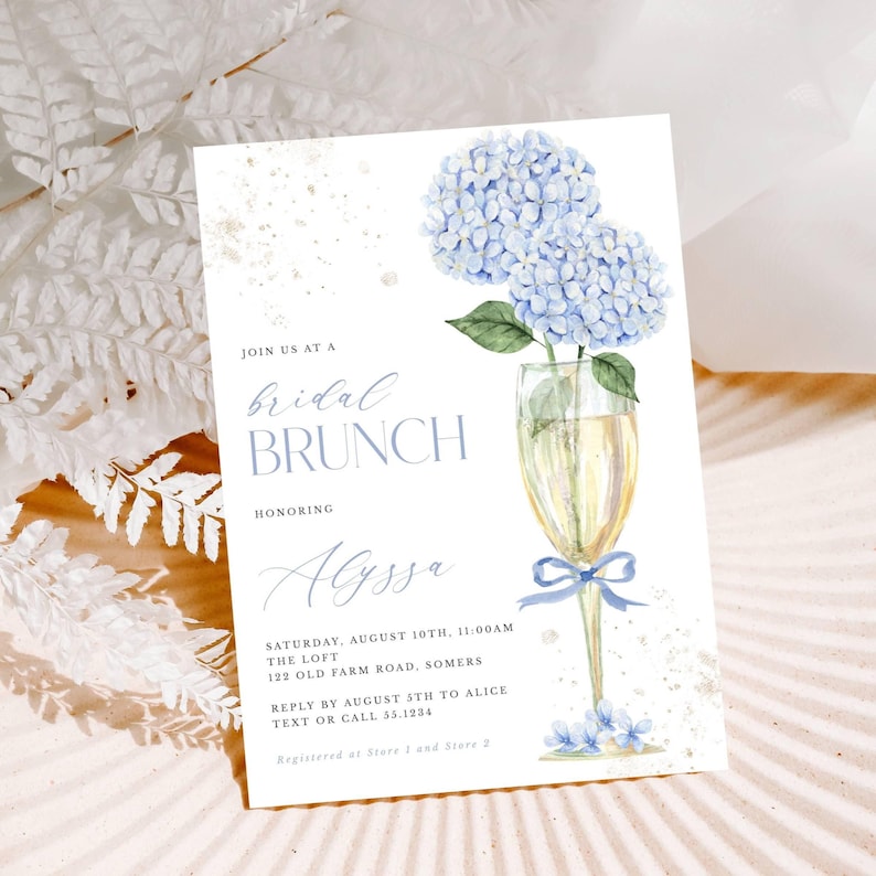 This beautiful design features delicate blue hydrangea flowers, in a gold champagne glass, perfect for your bridal shower or brunch celebration.