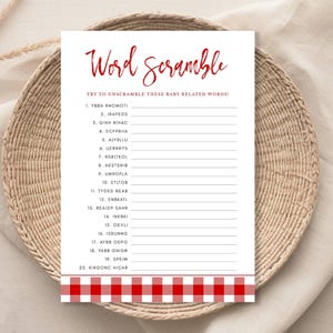 May include: A white Word Scramble game sheet with red text and a red and white checkered border. The sheet is on a woven basket. The game is for unscrambling baby-related words.