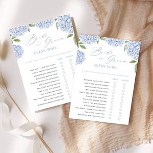 May include: Two white rectangular game cards titled Bride or Groom Guess Who with blue hydrangea floral illustrations at the top. The cards feature a list of questions with circular checkboxes for Bride and Groom selections printed in black ink.