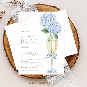 This beautiful design features delicate blue hydrangea flowers, in a gold champagne glass, perfect for your bridal shower or brunch celebration.