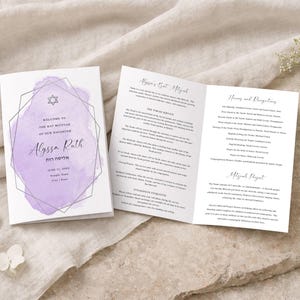 Puede incluir: Una invitación tríptica para un Bat Mitzvah, con un diseño morado estilo acuarela. La portada dice "Bienvenida al Bat Mitzvah de nuestra hija, Alyssa Ruth". En el interior, la invitación detalla el servicio y los honores.