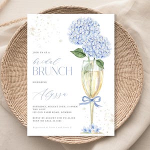 This beautiful design features delicate blue hydrangea flowers, in a gold champagne glass, perfect for your bridal shower or brunch celebration.