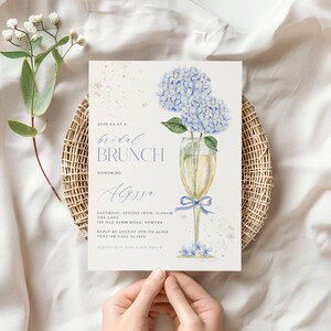 This beautiful design features delicate blue hydrangea flowers, in a gold champagne glass, perfect for your bridal shower or brunch celebration.