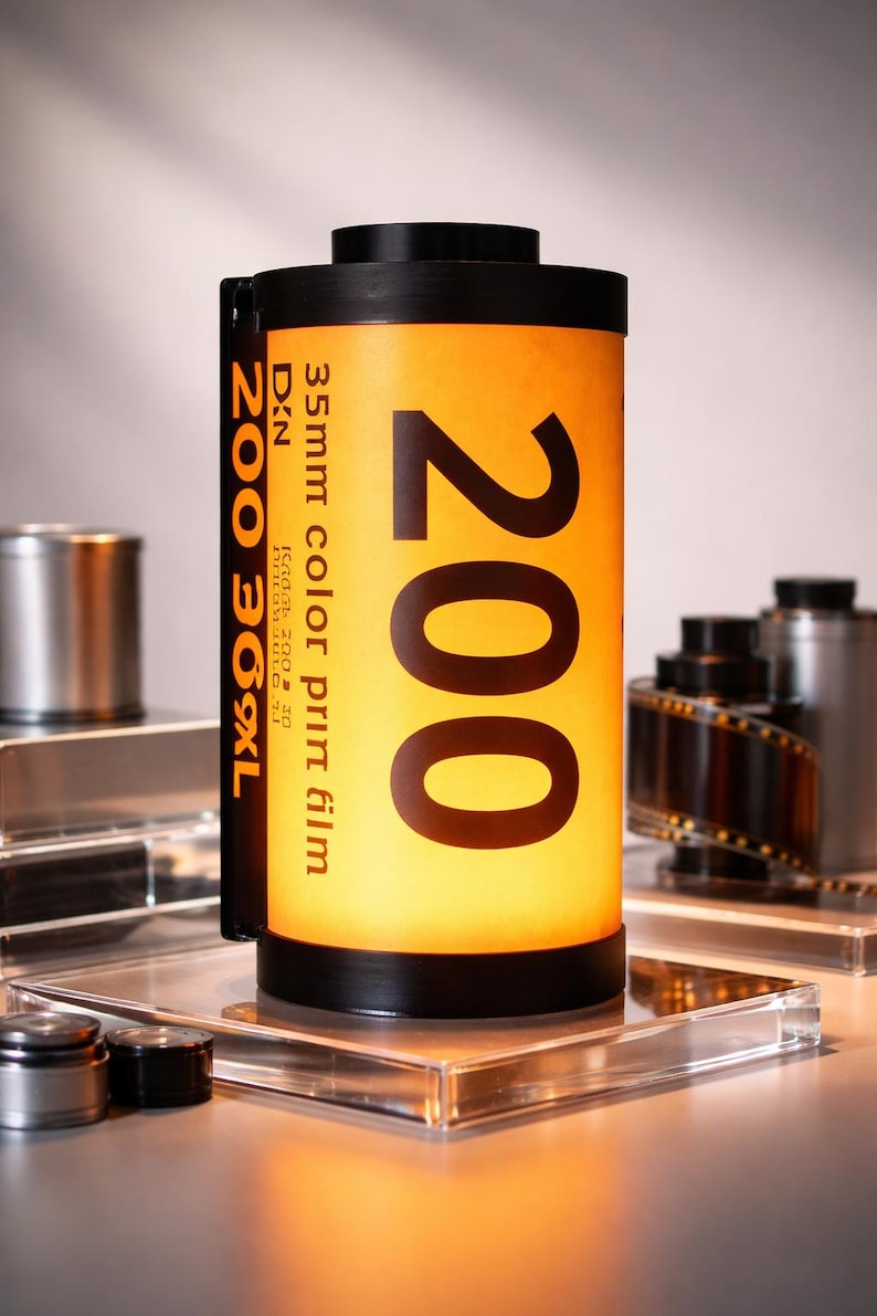 May include: A cylindrical film canister with the number "200" prominently displayed on a yellow label. The text "35mm color print film" is also visible. The canister is black on the top and bottom.