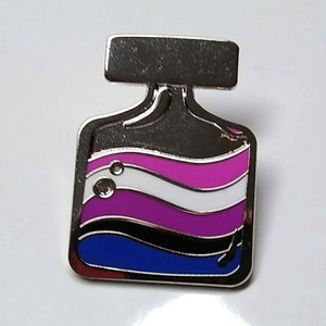 May include: A silver pin shaped like a bottle with a black top and a blue, black, white, pink and purple liquid inside. The liquid is in the shape of waves.