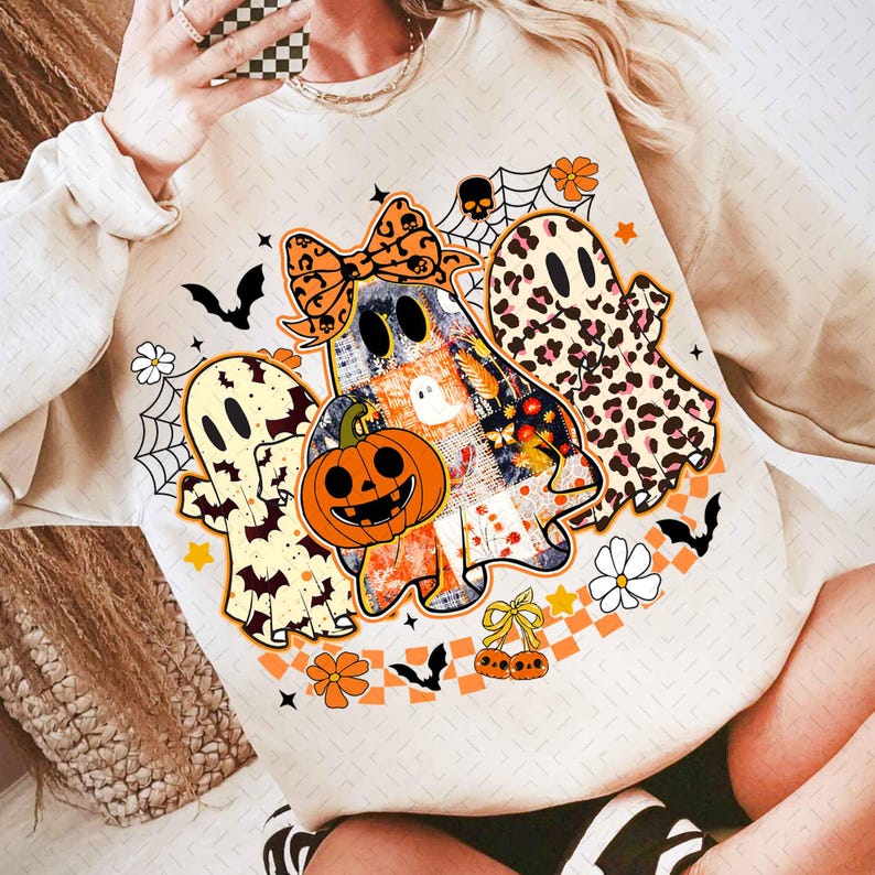 Peut inclure: Sweat-shirt beige avec un motif sur le th&egrave;me d'Halloween. Le graphisme comprend trois fant&ocirc;mes, une citrouille, des chauves-souris, des toiles d'araign&eacute;es et des motifs floraux. Les fant&ocirc;mes ont des motifs vari&eacute;s, dont l&eacute;opard et patchwork. Le design est orange, noir et blanc.