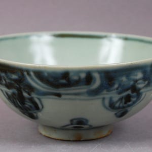 Peut inclure: Un bol en céramique avec un intérieur bleu clair et un extérieur blanc. Le bol présente un motif décoratif bleu foncé autour du bord. Le bol mesure environ 15 cm de diamètre et 8 cm de hauteur.