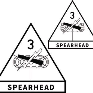 Può includere: Due emblemi triangolari in bianco e nero. Ognuno presenta il numero 3, un'illustrazione simile a un carro armato con un fulmine e la parola "SPEARHEAD" in un rettangolo sottostante. Il design è semplice e audace.