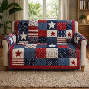 May include: A quilted sofa cover with a patchwork design in red, white, and blue. The cover features star and anchor patterns, with a red border. The sofa arms also have star patterns.