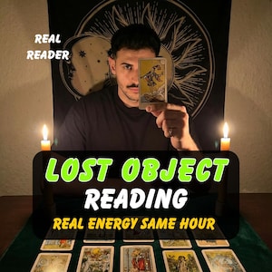 May include: A tarot card reading setup featuring a person holding a card, with text overlays reading REAL READER, LOST OBJECT READING, and REAL ENERGY SAME HOUR. Two lit candles flank the cards on a green surface against a sun and moon tapestry.