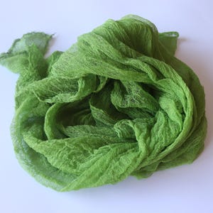 Op de afbeelding: Een groene stofstaal met een gekreukelde textuur. De stof is zacht en doorschijnend en perfect om aan elk project een vleugje kleur en textuur toe te voegen.