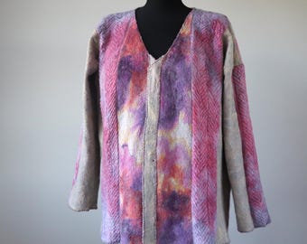 Peut inclure: Veste à manches longues et col en V dans les tons de rose, de violet et de gris. La veste présente un panneau central avec un motif aquarelle, flanqué de rayures verticales roses en chevrons. Les manches et les bords sont gris uni.