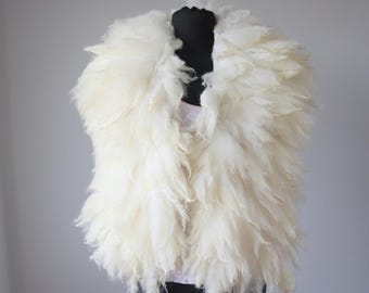May include: A white fluffy vest made of wool, displayed on a mannequin. The vest has a loose, flowing style and is perfect for adding a touch of warmth and texture to any outfit.
