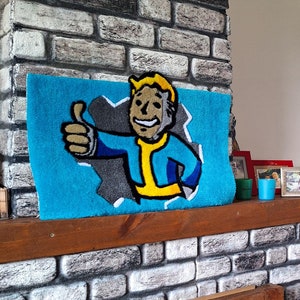 May include: A brick fireplace with a wooden mantel and a blue rug with a cartoon character on it. The rug features a character with a yellow jumpsuit and a blue shirt giving a thumbs up. There are small framed pictures on the mantel.