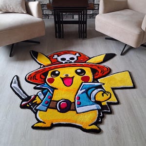 K&ouml;nnte beinhalten: Ein individuell geformter Teppich mit dem gelben Charakter Pikachu, der einen roten Piratenhut mit wei&szlig;em Totenkopf-Emblem, eine blaue Jacke und einen braunen G&uuml;rtel tr&auml;gt und ein silbernes Schwert in der rechten Hand h&auml;lt.
