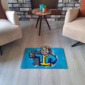 May include: A blue and gray rug with a cartoon character on it. The character is a man with yellow hair and a blue jumpsuit. He is giving a thumbs up. The rug is on a light gray floor.