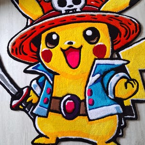 K&ouml;nnte beinhalten: Ein gelber getufteter Teppich in Form einer Figur, die einen roten Strohhut mit einem wei&szlig;en Totenkopf-Emblem tr&auml;gt. Die Figur hat rote Wangen, eine blaue Jacke mit wei&szlig;em Saum, einen braunen G&uuml;rtel mit einem roten Edelstein und h&auml;lt ein Schwert.