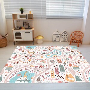 May include: A colorful play mat with a road, houses, animals, and other fun elements. The mat is perfect for kids to play on and learn.