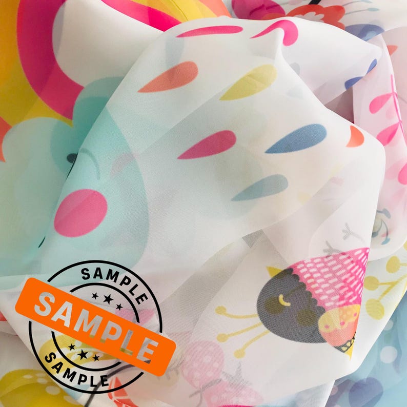 May include: A white sheer fabric with a colorful print of birds, flowers, and raindrops. The fabric has a sample label with the word "SAMPLE" printed on it.