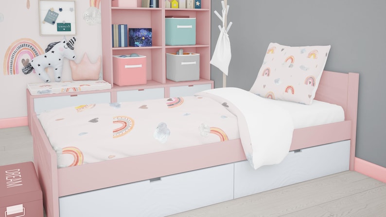 May include: A pink twin-sized bed with a white and pink rainbow patterned duvet cover and a matching pillow. The bed has a white headboard and footboard with storage drawers. The bed is in a room with a pink bookshelf and a white unicorn stuffed animal.