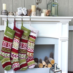 May include: Four personalised Christmas stockings with green, red and white knit patterns hang on a white fireplace mantel. The stockings are labelled "Jordan", "Julian", "Dolce", and "Allen".