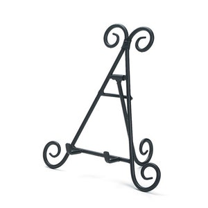 May include: Black metal easel stand with a decorative scroll design. The stand is designed to hold plates or other flat objects.