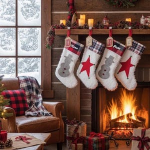 May include: A cozy Christmas scene with a lit fireplace, stockings, and gifts. Four white stockings hang above the fireplace, two with snowman designs and two with red stars. A plaid blanket and pillow adorn a leather armchair.