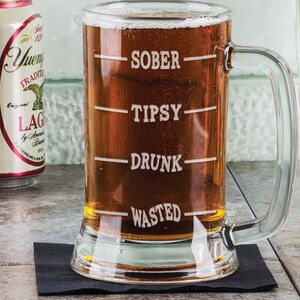 May include: A clear glass beer mug with a handle. The mug has four lines etched on the side with the words "Sober", "Tipsy", "Drunk", and "Wasted" printed on the lines.