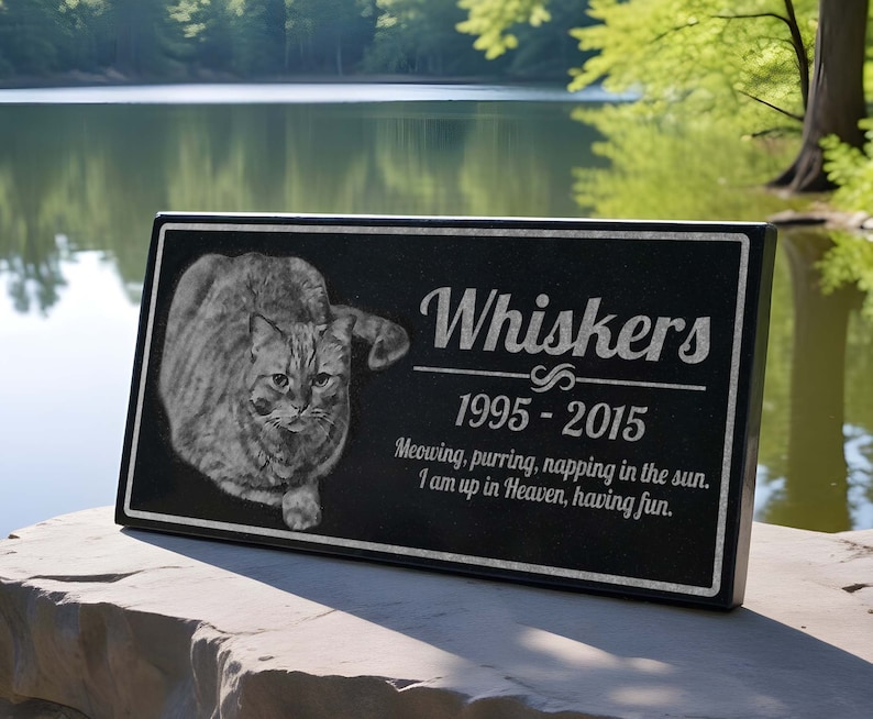 May include: Black granite pet memorial plaque with a photo of a tabby cat and the text "Whiskers 1995-2015 Meowing, purring, napping in the sun. I am up in Heaven, having fun."