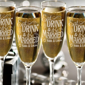 Puede incluir: Cuatro copas de champ&aacute;n con el texto "Eat Drink & Be Married" y los nombres "Sara & Logan" grabados en el vidrio.