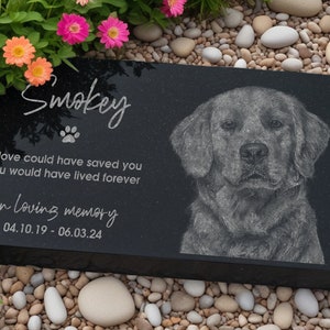 May include: Black granite pet memorial with a paw print and the inscription "Smokey". The inscription continues with "If love could have saved you, you would have lived forever. In loving memory 04.10.19 - 06.03.24". A black and white etched image of a dog is on the right side of the memorial.